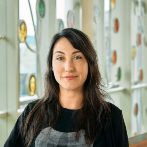 A light brown woman with long brown hair and brown eyes in black shirt.